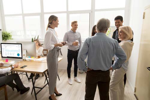 Senior Executives talking to group of younger managers (source: freepik.com)