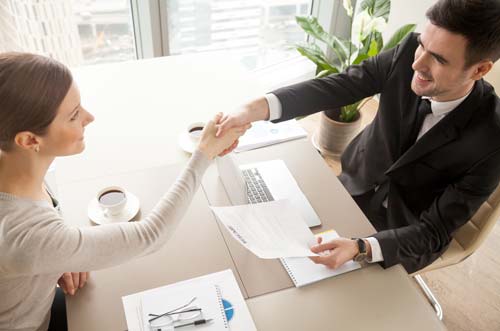 Executive shaking hands with hiring manager after working with headhunter (source: freepik.com)